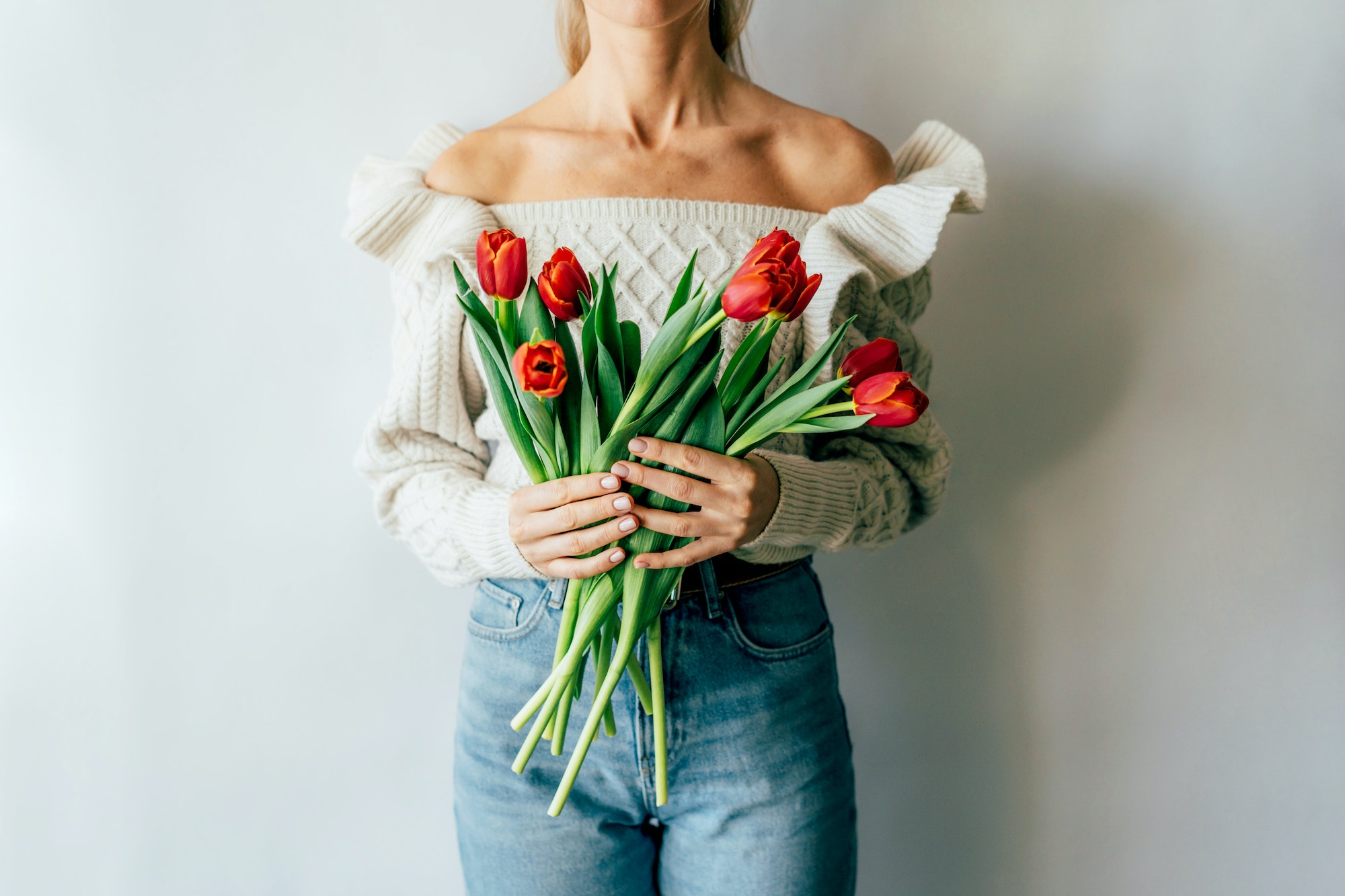 Woman with bouquet of fresh spring blooming tulips.